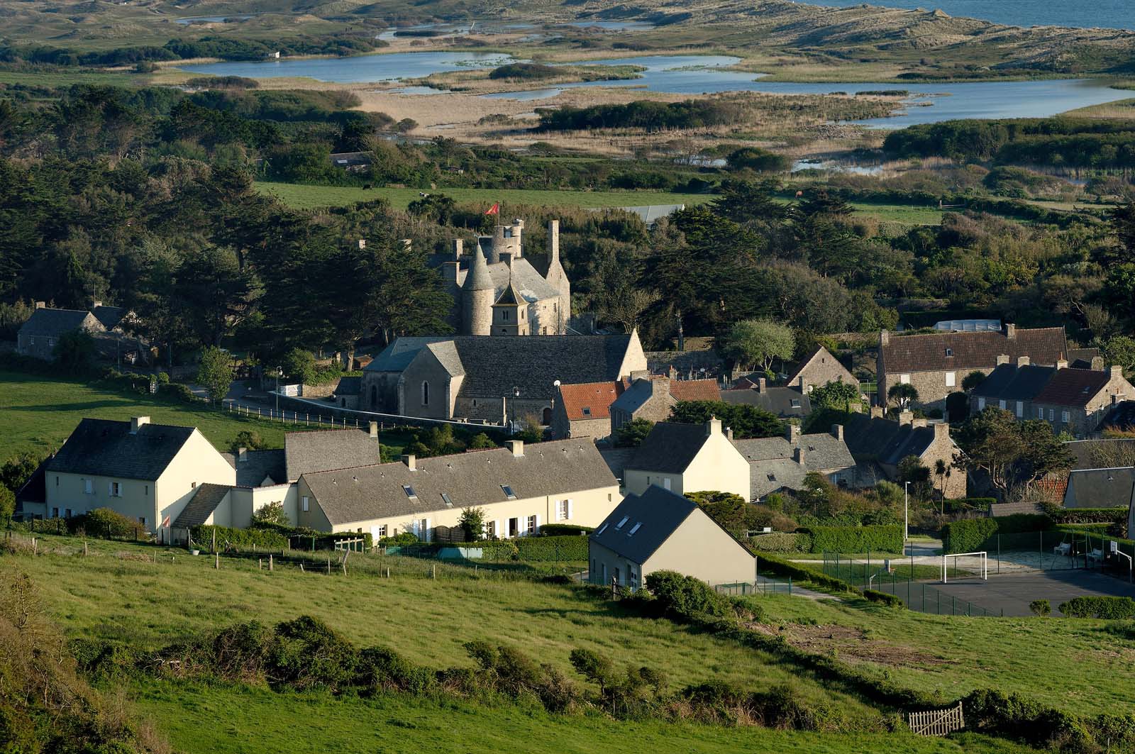 Le village de Vauville fait partie des sites classés de la Hague, Cap Cotentin. Les Pierres Pouquelées, galerie néolithique, sont un témoignage de l'Antiquité.La mare de Vauville est une réserve naturelle. Créée en 1976 c'est l'une des 135 réserves naturelles de France. Géré par le Groupe Ornithologique Normand depuis 1983, c'est un marais d'eau douce protégé de la mer par un étroit cordon dunaire. La mare de Vauville fait 62 ha, il y a plus de 150 espèces d'oiseaux ainsi que de 350 plantes et 16 espèces de batraciens.Un édifice autrefois religieux domine le village. C'est le prieuré de Vauville construit dans les landes, sur le haut d'une colline.Créé par Eric et Nicole Pellerin en 1947, l'exceptionnel jardin botanique du château de Vauville occupe plus de 40 000 m2. Abritant plus de 1000 espèces de l'hémisphère austral, le jardin entoure le château de Vauville dans une ambiance subtropicale tout à fait surprenante.